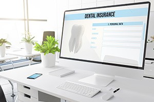 Patient reviewing dental insurance coverage for implants on computer