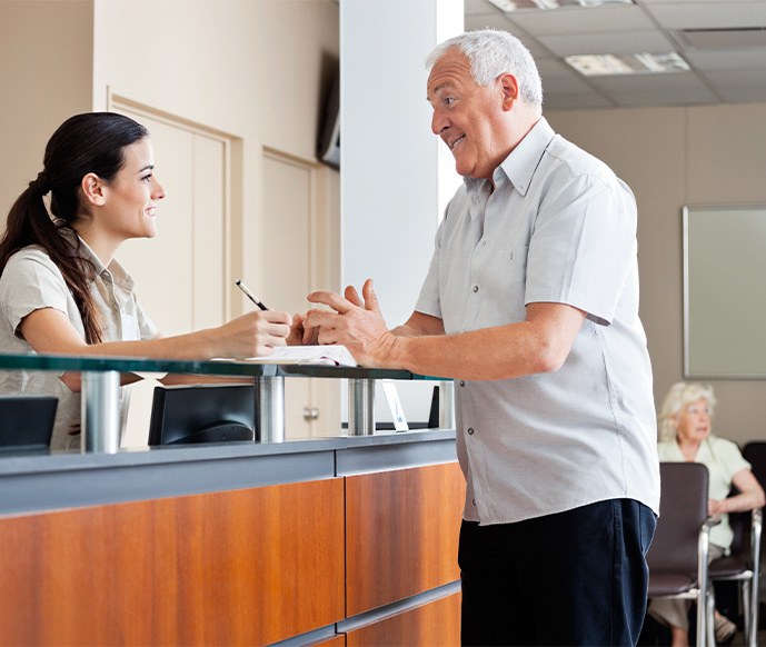 A front desk staff speaking with a patient