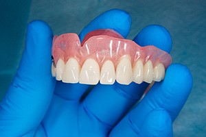 Dentist holding a full denture