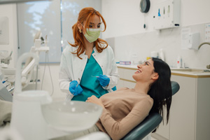 Patient in treatment chair smiling at dentist
