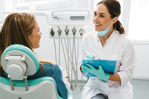 Smiling dentist taking notes on clipboard