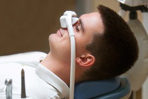 Patient relaxing while breathing in nitrous oxide in treatment chair